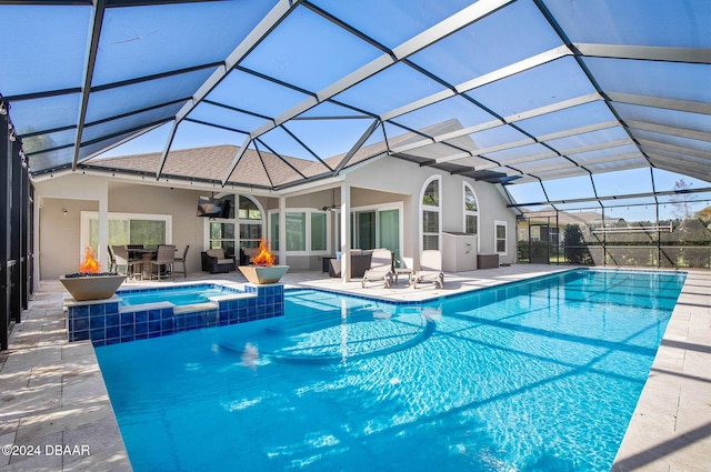 view of pool featuring a patio area, a lanai, and an in ground hot tub