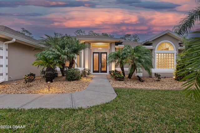 exterior entry at dusk with a lawn