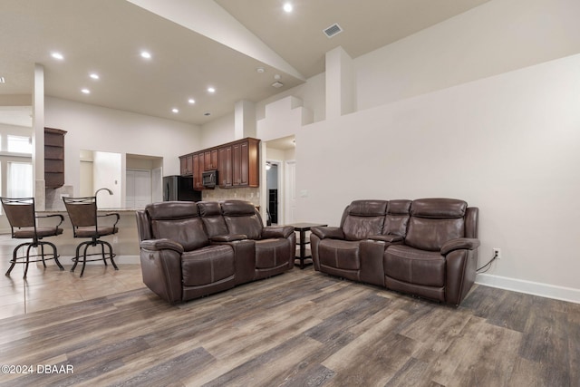 living room featuring dark hardwood / wood-style flooring and high vaulted ceiling