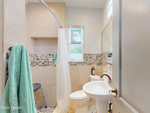 650 S Pine St, New Smyrna Beach, FL 32169 - bathroom with a sink, a tile shower, toilet, and tile walls
