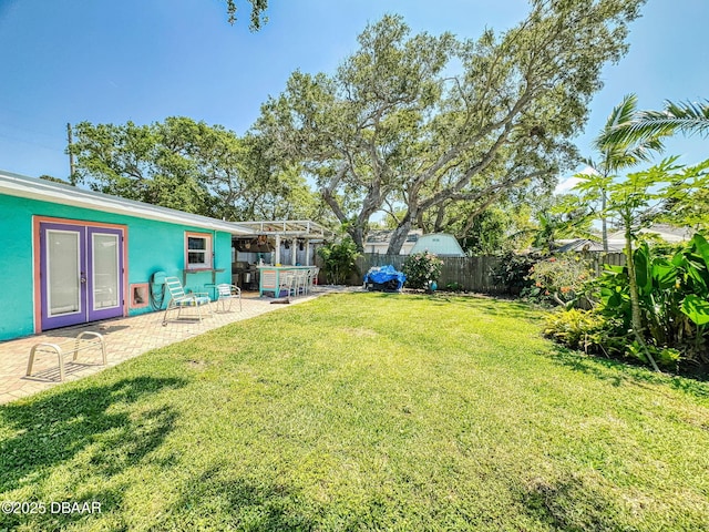 650 S Pine St, New Smyrna Beach, FL 32169 - view of yard featuring a patio, french doors, and a fenced backyard