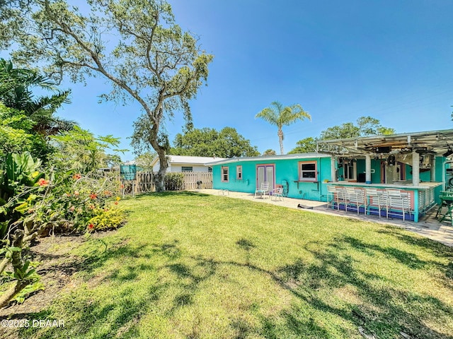650 S Pine St, New Smyrna Beach, FL 32169 - back of house featuring fence, outdoor dry bar, a yard, and a patio area