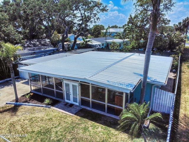 650 S Pine St, New Smyrna Beach, FL 32169 - rear view of property featuring a lawn, french doors, metal roof, and a sunroom