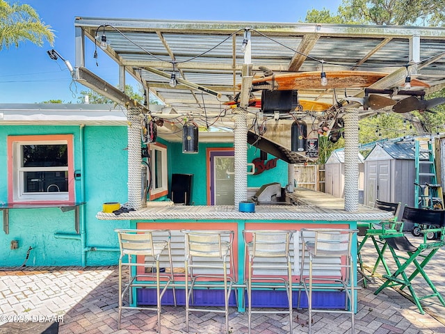 650 S Pine St, New Smyrna Beach, FL 32169 - view of patio / terrace with outdoor dry bar, an outdoor structure, and a shed