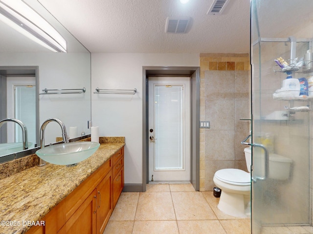 650 S Pine St, New Smyrna Beach, FL 32169 - bathroom featuring toilet, a textured ceiling, tile patterned floors, a shower stall, and visible vents