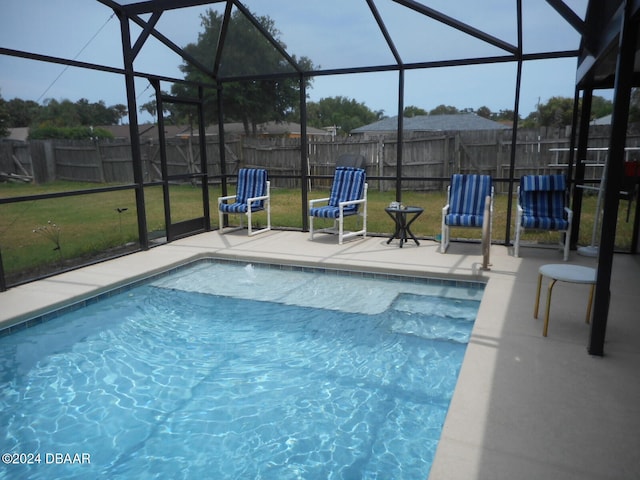 view of swimming pool featuring a patio, a lanai, and a yard