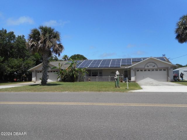 ranch-style house featuring a garage, solar panels, and a front lawn