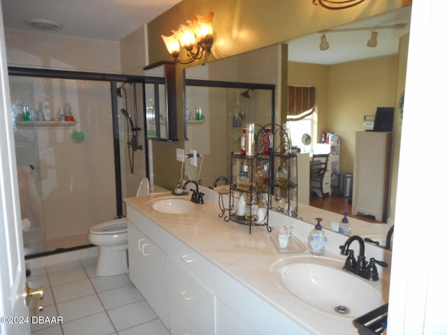 bathroom with vanity, a shower with shower door, tile patterned floors, and toilet