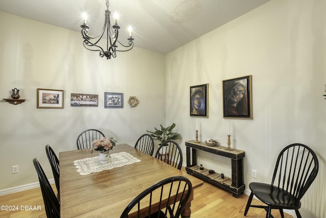 dining space with a notable chandelier and light hardwood / wood-style floors