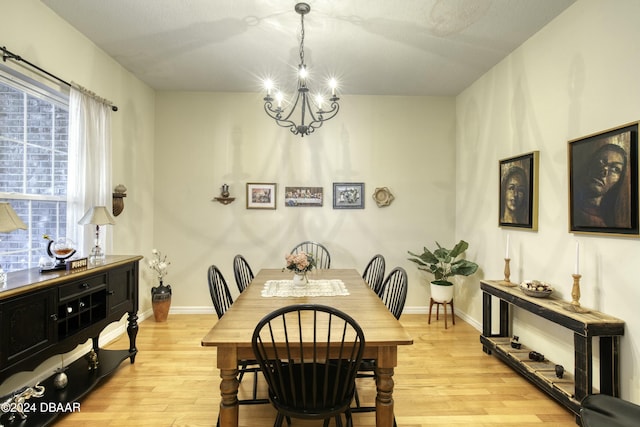 dining room with a chandelier, a textured ceiling, and light hardwood / wood-style flooring