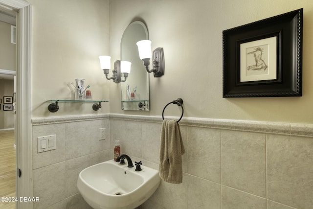 bathroom featuring sink and tile walls