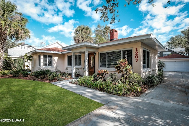 view of front of house with a garage, a front lawn, and an outdoor structure