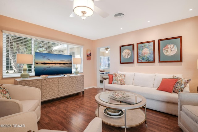 living room featuring ceiling fan and dark hardwood / wood-style floors