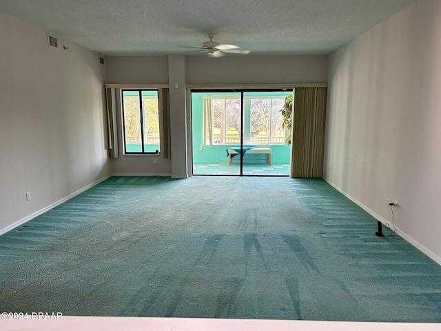 carpeted spare room with ceiling fan and a textured ceiling