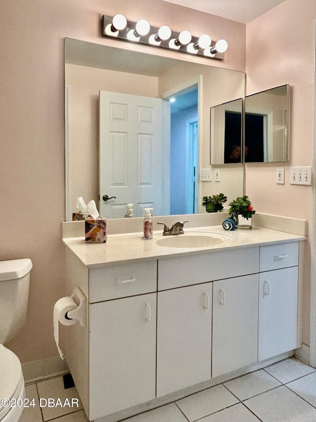 bathroom featuring tile patterned flooring, vanity, and toilet