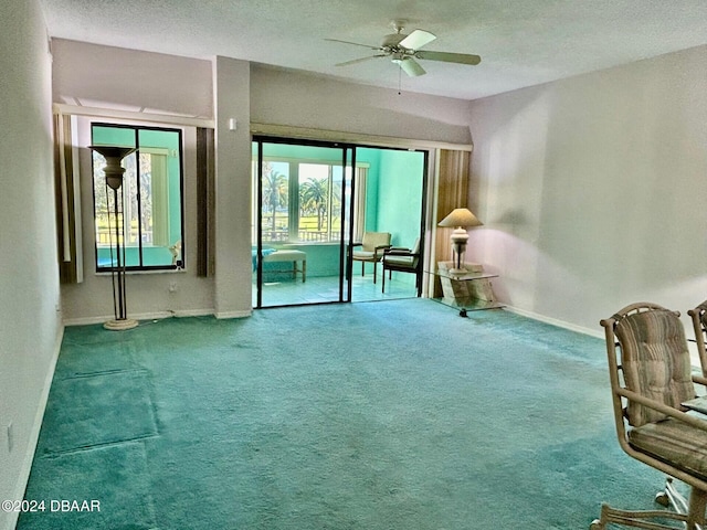 unfurnished room featuring a textured ceiling, carpet floors, and ceiling fan