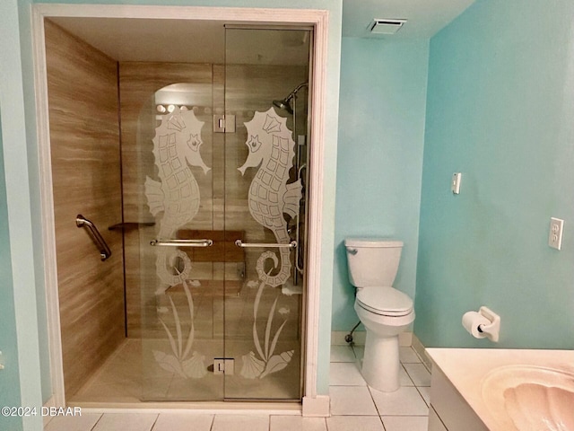 bathroom with tile patterned flooring, vanity, a shower with shower door, and toilet