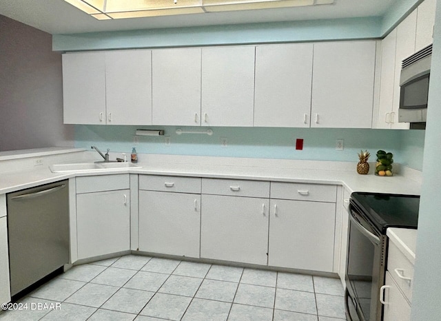 kitchen featuring white cabinets, appliances with stainless steel finishes, light tile patterned floors, and sink