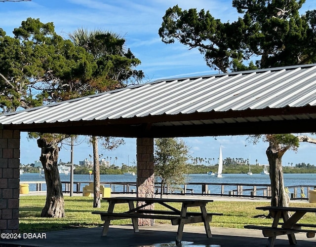 surrounding community featuring a lawn and a water view