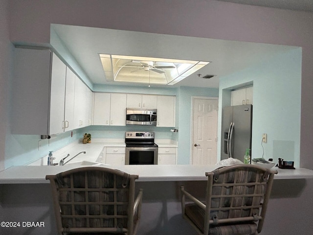 kitchen with white cabinetry, sink, appliances with stainless steel finishes, and a skylight