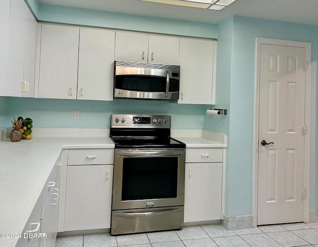 kitchen with white cabinets, stainless steel appliances, and light tile patterned floors