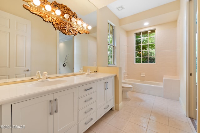 bathroom with a bathtub, vanity, toilet, and tile patterned floors