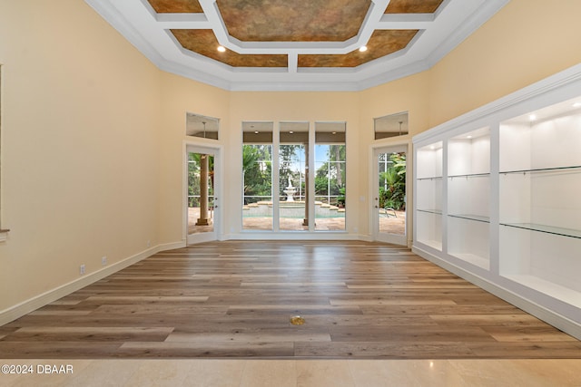 unfurnished room with crown molding, hardwood / wood-style floors, a high ceiling, and coffered ceiling