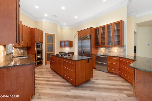 kitchen featuring light hardwood / wood-style flooring, sink, built in appliances, and a center island