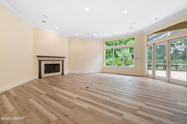 unfurnished living room with french doors, light hardwood / wood-style flooring, and crown molding