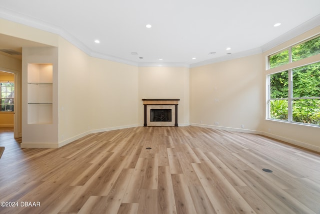 unfurnished living room with crown molding and light hardwood / wood-style flooring