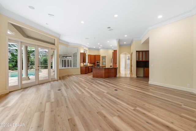 unfurnished living room with french doors, light hardwood / wood-style floors, and crown molding