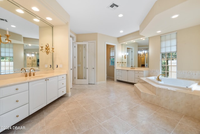 bathroom with vanity, tiled bath, tile patterned floors, and plenty of natural light