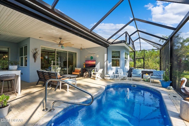 view of swimming pool featuring an outdoor hangout area, a patio, glass enclosure, and ceiling fan