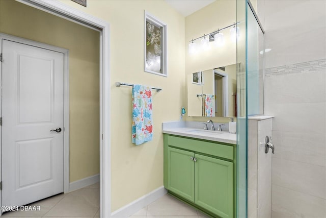 bathroom with tiled shower, vanity, and tile patterned floors