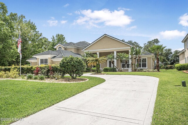 1766 Roscoe Turner Trl, Port Orange, FL 32128 - view of front facade with a front lawn, stucco siding, a tile roof, and curved driveway