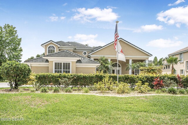 1766 Roscoe Turner Trl, Port Orange, FL 32128 - mediterranean / spanish-style home featuring a front yard, a tiled roof, and stucco siding