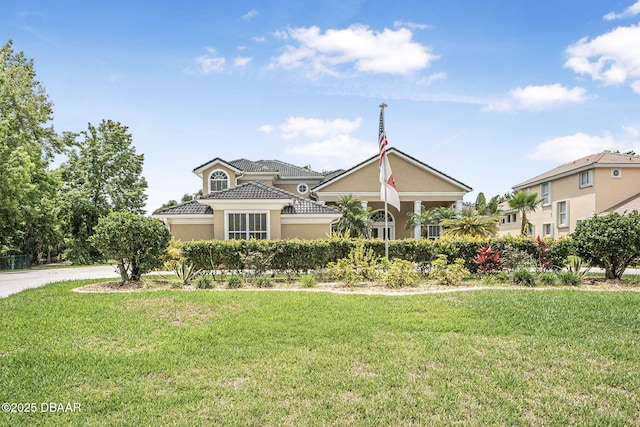 1766 Roscoe Turner Trl, Port Orange, FL 32128 - view of front of house featuring a front lawn, stucco siding, and a tiled roof