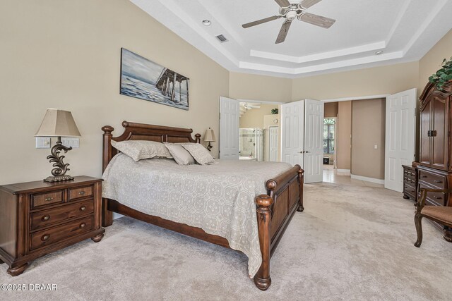 1766 Roscoe Turner Trl, Port Orange, FL 32128 - bedroom featuring light carpet, a raised ceiling, connected bathroom, a ceiling fan, and baseboards