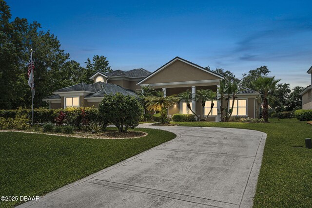 1766 Roscoe Turner Trl, Port Orange, FL 32128 - view of front of home with a front lawn, curved driveway, a tile roof, and stucco siding