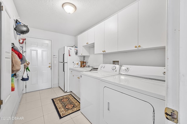 1766 Roscoe Turner Trl, Port Orange, FL 32128 - laundry room featuring cabinet space, independent washer and dryer, a textured ceiling, and light tile patterned flooring