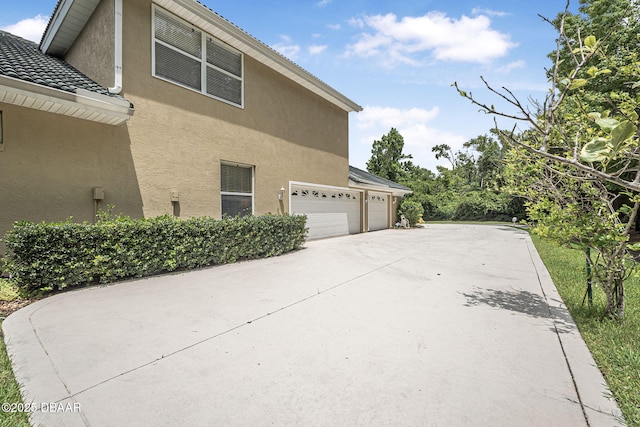 1766 Roscoe Turner Trl, Port Orange, FL 32128 - view of property exterior featuring stucco siding, concrete driveway, and a garage