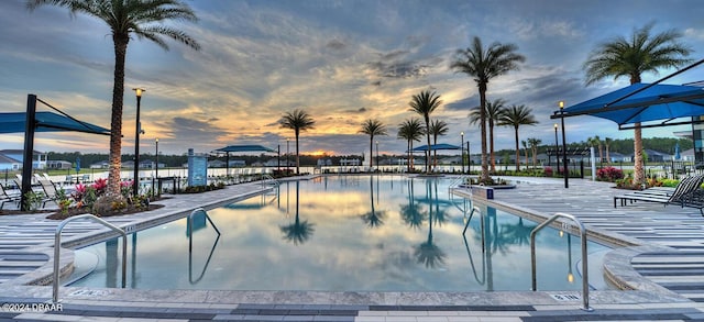 pool at dusk featuring a patio