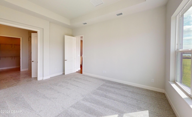 unfurnished bedroom with a walk in closet and carpet floors