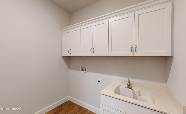 clothes washing area featuring hookup for an electric dryer, hookup for a washing machine, cabinets, sink, and hardwood / wood-style floors