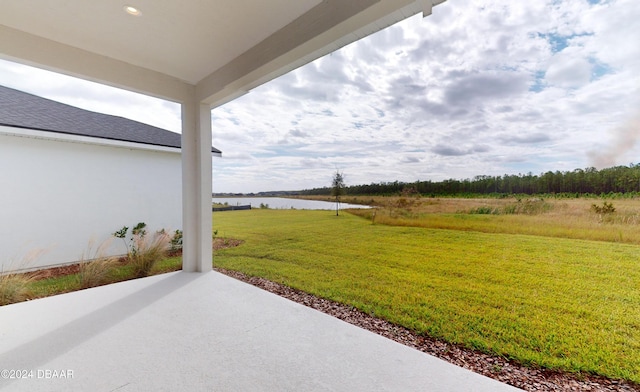 view of yard with a water view and a patio