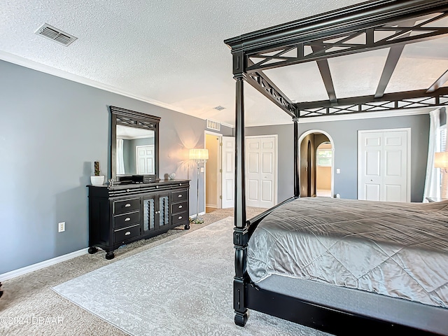 carpeted bedroom with a textured ceiling and a closet