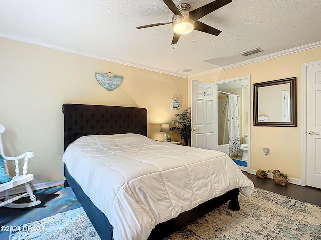 bedroom with a textured ceiling, ceiling fan, crown molding, and connected bathroom