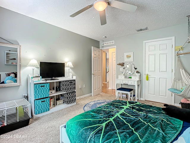 bedroom with carpet flooring, a textured ceiling, and ceiling fan