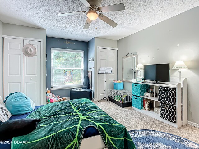 carpeted bedroom featuring ceiling fan and a textured ceiling