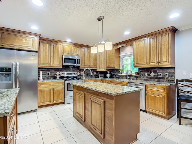 kitchen featuring a kitchen island with sink, appliances with stainless steel finishes, hanging light fixtures, and light tile patterned floors